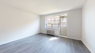 Located at 3111 Eglinton Ave E in Toronto's Scarborough neighbourhood, this two-bedroom, one-bathroom unit offers a well-organized layout across a single floor. The interior is finished with grey laminate flooring throughout the living areas and bedrooms, complemented by clean white walls that create a bright, neutral palette.

The kitchen has been thoughtfully updated with white cabinetry, a white subway tile backsplash, stainless steel appliances including a refrigerator, stove, and built-in microwave, as well as light-toned tile flooring. It opens conveniently to the living area, supporting an easy flow between spaces.

The living room features a large window and a classic radiator, allowing natural light to fill the room while offering views of the surrounding greenery and neighbouring brick buildings. A private balcony is accessible from this area, providing an outdoor retreat with open views of the landscaped courtyard below.

Both bedrooms are well-proportioned, with the primary bedroom offering a mirrored sliding closet and window with natural light. The second bedroom also includes a window with a radiator beneath it and a ceiling-mounted light fixture.

The bathroom is finished with crisp white subway tile surrounding the soaker tub and shower combination, maintaining the clean, classic aesthetic found throughout the unit. A hallway connects all rooms efficiently, completing this practical and updated urban home.