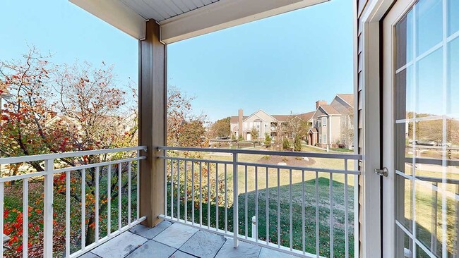 Enjoy serene views from your private balcony, overlooking a landscaped green space and nearby residential buildings. - Ridge Pointe Villas