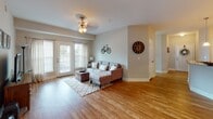 Located at 2067 Springdale Ln in Gallatin, Tennessee, this single-floor residence offers a thoughtfully designed layout with a warm, welcoming ambiance throughout. The living room features rich hardwood flooring, a ceiling fan with light fixture, and French doors that invite natural light and provide access to an outdoor patio area, creating a bright and airy atmosphere. The adjacent dining area is defined by a classic chandelier overhead and hardwood flooring that flows seamlessly from the living space, accommodating a round glass dining table beneath framed wall art.

The kitchen is equipped with dark espresso cabinetry, granite-style countertops, a breakfast bar with pendant lighting, and black appliances, offering both functionality and style. Two well-proportioned bedrooms each feature plush carpet, ceiling fans, and windows that bring in natural light. The primary bedroom provides a serene retreat with ample space for furnishings.

Both bathrooms are finished with dark wood vanities, white countertops, large mirrors, and tile flooring, maintaining a consistent and polished aesthetic. The neutral color palette used throughout the home creates a cohesive and calming environment, making this Gallatin residence a comfortable and practical living space.
