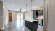 Located at 2101 Railway Ln. in Marysville, Ohio, this modern single-story home offers three bedrooms, two bathrooms, and a well-designed layout that balances functionality with contemporary style. A defining design element throughout is the polished concrete flooring, which lends a sleek, industrial-chic aesthetic to the entire home.

The kitchen is a standout feature, showcasing dark espresso cabinetry, a classic white subway tile backsplash, granite countertops, a central island with pendant lighting, and a full suite of stainless steel appliances — including a French door refrigerator, range, microwave, and dishwasher. The space is both practical and visually striking.

The bedrooms are bright and generously proportioned, each featuring ceiling fans and natural light from large windows with views of the surrounding neighborhood. The spacious primary bedroom includes a double-door closet with warm wood-toned doors that complement the home's modern palette.

The two bathrooms are thoughtfully appointed. The primary bath features a wide double-sink vanity, walk-in shower, and a tall dark storage cabinet. The secondary bath includes a full tub-shower combination and a dark vanity with ample drawer storage.

A bright living area with a ceiling fan and sliding glass door opens to outdoor views, completing this well-appointed home.