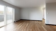 This one-bedroom, one-bathroom unit at Park Point in Glendale, Colorado offers a practical and well-organized layout across a single floor. The living room is bright and open, featuring hardwood-style flooring, baseboard heating, and a sliding glass door fitted with vertical blinds that opens onto a private balcony, allowing natural light to fill the space. The kitchen is efficiently designed in a U-shape configuration, complete with white cabinetry, dark granite-style countertops, and black appliances including a range and full-size refrigerator. Adjacent to the kitchen, there is additional space suitable for a dining area, also finished with hardwood-style flooring. A central hallway connects the main living areas to the bedroom and bathroom. The bedroom is carpeted for comfort and features a ceiling fan with a light fixture, a window with blinds offering outside views, baseboard heating, and a built-in double closet with bi-fold doors. The unit also benefits from three closets in total, providing generous storage throughout. The bathroom includes a vanity with a white cabinet, a medicine cabinet with mirror, and a shower-tub combination. Neutral wall tones and clean finishes give the unit a cohesive, move-in ready appearance.