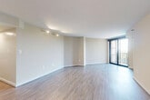 This thoughtfully designed one-bedroom, one-bathroom residence offers a functional and modern living experience across a single floor. The open-concept layout seamlessly connects the living, dining, and kitchen areas, all finished with light-toned wood-style flooring that adds warmth and continuity throughout the common spaces. Large sliding glass doors in the living room flood the area with natural light and provide direct access to a private balcony, offering pleasant outdoor views. The kitchen is a standout feature, equipped with stainless steel appliances including a gas range, microwave, and refrigerator, complemented by rich dark cabinetry, a subway tile backsplash, and an expansive white quartz peninsula with an undermount sink — ideal for both cooking and casual dining. A stacked washer and dryer unit is conveniently integrated near the kitchen. The spacious bedroom is carpeted for comfort, features a ceiling fan, and benefits from a well-sized window that brings in natural light. A dedicated closet provides ample storage. The bathroom is clean and contemporary, featuring a white vanity with quartz countertop, a combination shower/tub with built-in shelving, and tile flooring with wood-look accents. Neutral wall tones throughout create a calm, cohesive ambiance.