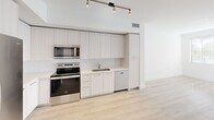 This one-bedroom, one-bathroom apartment in Boca Raton, FL offers a clean, modern aesthetic throughout its efficiently designed layout. Light-toned luxury vinyl plank flooring runs continuously across the entire unit, lending a cohesive, airy feel to every room.

The kitchen is a standout feature, outfitted with floor-to-ceiling light wood cabinetry, stainless steel appliances including a refrigerator, range, microwave, and dishwasher, and a sleek undermount sink with light quartz-style countertops. Overhead track lighting adds a contemporary touch and ensures the workspace is well-lit.

The living area flows naturally from the kitchen, offering an open, bright environment with crisp white walls. The bedroom is a comfortable size, featuring a ceiling fan with light fixture and a window dressed with blinds that invite natural light. Adjacent to the bedroom is a walk-in closet equipped with multi-tiered wire shelving for organized storage.

The bathroom is elegantly appointed with a large glass-enclosed walk-in shower featuring floor-to-ceiling neutral tile, a built-in bench, and a rain-style overhead showerhead. The unit also includes an in-unit stacked washer and dryer, adding everyday convenience to this well-appointed Boca Raton residence.