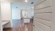 This single-floor residence in Birmingham, Alabama offers a clean, contemporary design throughout. The open-concept living and kitchen area is anchored by rich wood-look flooring, recessed lighting, and a ceiling fan, creating a bright and comfortable atmosphere. A sliding glass door allows natural light to filter into the living space, which flows seamlessly toward the kitchen.

The kitchen is well-appointed with white upper shaker cabinets, light gray lower cabinets, and a classic white subway tile backsplash. Granite countertops extend across the workspace and onto a central island equipped with a sink, offering additional prep and seating space. A full suite of stainless steel appliances — including a refrigerator, electric range, and over-the-range microwave — completes the kitchen.

The bedrooms feature plush carpeting and windows with blinds that provide natural light and privacy. Multiple bathrooms are outfitted with granite-topped vanities, wood-look flooring, and tub-shower combinations with tiled surrounds and curved curtain rods. The consistent use of neutral tones, granite surfaces, and modern fixtures throughout gives the entire space a cohesive and polished feel.