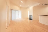 Located at 7917 Selma Ave in Los Angeles, CA 90046, this single-floor unit offers a clean, modern aesthetic throughout. Light-toned hardwood flooring flows seamlessly across the living areas and bedrooms, creating a warm and cohesive feel. The open-concept living and dining area is anchored by recessed lighting and features a fireplace, adding both style and function. A tray ceiling detail adds architectural interest to the main living space.

Multiple sliding glass doors connect the interior to private balconies, inviting abundant natural light and offering pleasant views of the surrounding neighborhood's greenery. The kitchen is well-appointed with light maple cabinetry featuring frosted glass inserts, dark granite countertops, a breakfast bar peninsula, stainless steel appliances, and tile flooring.

The bedrooms are generously sized with high ceilings, crisp white walls, recessed lighting, and their own sliding door balcony access, enhancing the bright and airy atmosphere. Interior glass-panel doors add a modern, translucent design touch between rooms.

The bathrooms are finished with tile flooring and maple vanities topped with distinctive stone countertops. One bathroom features a unique vessel sink, while the other includes a shower-tub combo, both reflecting a thoughtful, detail-oriented design sensibility throughout the space.