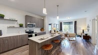 Located in the heart of Louisville, Kentucky, this thoughtfully designed 2-bedroom, 2-bathroom residence offers a well-appointed single-floor layout with contemporary finishes throughout. The open-concept kitchen and living area serves as the central hub of the home, featuring dark wood-tone cabinetry, white quartz countertops, a subway tile backsplash, stainless steel appliances including a side-by-side refrigerator and electric range, and a peninsula with pendant lighting and bar seating — ideal for both cooking and entertaining. The adjacent living room is bright and inviting, with wood-style flooring and large windows that bring in natural light and views of the surrounding greenery.

Both bedrooms are comfortably sized with plush carpeting. The primary bedroom includes a generous walk-in closet outfitted with dual hanging rods and shelving. The en-suite primary bathroom features wood-tone cabinetry, a dual-sink vanity with white countertops, wood-style flooring, and a glass-enclosed shower. The second bathroom offers a full tub-shower combination and a single vanity, conveniently positioned near the stacked in-unit washer and dryer. Two closets provide ample storage throughout the residence.
