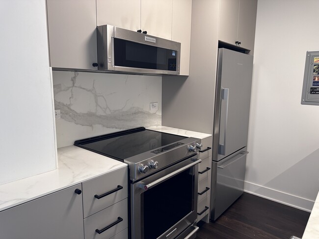 Sleek microwave and electric range. The veining wraps around the corner. - 1325 N State Pky