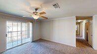 This well-appointed 4-bedroom, 2-bathroom single-story home in Waco, Texas offers a comfortable and functional layout. The living room features plush carpeting, crown molding, and a ceiling fan with light kit, along with sliding glass doors that open to a private balcony, inviting natural light into the space. The kitchen is equipped with warm wood cabinetry, dark countertops, a built-in microwave, and a gas range, all illuminated by track lighting. A peninsula counter connects the kitchen to the adjacent dining area, creating an open and social atmosphere. The generously sized primary bedroom includes its own ceiling fan and direct access to a full bathroom featuring a tiled tub-shower combo, a wood-toned vanity, and a large mirror. The three additional bedrooms are carpeted, each with a ceiling fan and windows with blinds that allow for natural light. Crown molding details are present throughout several rooms, adding a refined finish. The dedicated laundry room houses a full-size washer and dryer with built-in wire shelving above. The two bathrooms feature hardwood-style flooring, completing a clean and cohesive interior. This home offers a practical, well-designed space suitable for a variety of living arrangements.