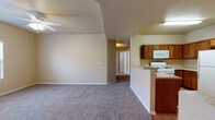 Located at 9435 Diana Dr in El Paso, Texas, this single-story residence offers a well-designed, functional layout with comfortable living spaces throughout. The open-concept living area greets you upon entry, featuring warm neutral tones, plush carpeting, and a ceiling fan with light fixture. Natural light filters in through windows fitted with blinds, creating a bright and welcoming atmosphere. The space flows seamlessly into a half-wall breakfast bar that connects the living area to the kitchen.

The kitchen is thoughtfully appointed with rich wood cabinetry, light-toned countertops, and durable wood-look flooring. It comes fully equipped with a gas range, built-in microwave, dishwasher, and a full-size refrigerator, providing everything needed for everyday cooking and meal preparation.

The bedrooms are carpeted and sized generously, each offering closet storage and a calm, neutral color palette. The hallway connects multiple rooms efficiently, enhancing the overall flow of the floor plan. Two full bathrooms are present, each featuring a shower-tub combination, wood-look flooring, and clean white fixtures, offering practicality and ease of maintenance. Overall, this residence presents a straightforward and comfortable living environment in a convenient El Paso location.