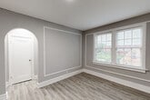 Located at 5345 Cabanne Ave in St. Louis, MO, this 2-bedroom, 1-bathroom residence offers a thoughtfully designed layout across a single floor. Light wood-style flooring flows consistently throughout the space, complemented by neutral gray walls and crisp white trim, creating a clean and cohesive aesthetic.

The kitchen is well-equipped with gray shaker-style cabinetry, granite-look countertops, a gas range, and a subway tile backsplash. Natural light enters through a window above the counter, and a door provides convenient exterior access.

The living room is a standout space, featuring elegant wall molding details and a graceful arched doorway that adds architectural character. Large windows allow generous natural light and neighborhood views, enhancing the room's openness.

Both bedrooms are comfortably sized, with the primary bedroom offering notable square footage. Each room benefits from natural light via well-positioned windows with outdoor views of the surrounding neighborhood.

A narrow hallway connects the bedrooms to the full bathroom, which is a visual highlight of the home. It features floor-to-ceiling blue-gray subway tile surrounding the tub and shower, chrome fixtures, a white vanity, and a gridded window that brings in soft natural light, creating a bright and stylish retreat.