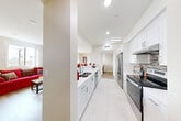 Located at 1029 W 223rd St in Torrance, CA, this well-appointed 2-bedroom, 2-bathroom single-floor residence offers a thoughtfully designed layout with modern finishes throughout. The open-concept kitchen is outfitted with white shaker cabinetry, dark granite countertops, a mosaic tile backsplash, stainless steel appliances including a French door refrigerator and electric range, and a double-basin sink — all finished with large-format light tile flooring. The kitchen flows seamlessly into the dining area, which features a sliding glass door that opens to an outdoor balcony, filling the space with natural light and neighborhood views. The living room features warm hardwood-style flooring, recessed lighting, and a window overlooking the surroundings, creating a comfortable and inviting atmosphere. The primary bedroom is a standout, boasting expansive floor-to-ceiling corner windows that frame broad outdoor views and flood the room with natural light. The en-suite bathroom includes a dual-sink vanity with white cabinetry, a soaking tub, and a glass-enclosed shower. The second bedroom is well-sized with a closet and natural light. A hallway with an additional closet connects the private quarters to the main living areas, and two closets provide ample storage throughout the home.