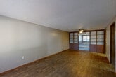 Located at 3030 Continental Colony Pkwy in Atlanta, GA, this single-story, three-bedroom, one-bathroom home offers a practical and well-organized layout across a comfortable footprint. The spacious living room is a standout feature, showcasing rich hardwood-style flooring, a textured ceiling, and a distinctive built-in shelving unit with wood-framed glass panels that adds character and storage. A ceiling fan with a light fixture completes the room, enhancing both comfort and functionality.

The kitchen is efficiently designed with warm wood cabinetry, granite-look countertops, and white appliances including a refrigerator, electric range, and dishwasher. Light wood-style flooring ties the space together for easy maintenance.

The three bedrooms are carpeted for comfort and each features a ceiling fan, natural light from windows with blinds, and neutral wall tones. The primary bedroom offers a generous layout with views to the outdoors.

The full bathroom is cleanly appointed with a white vanity, toilet, and a tub-shower combination, accented by wood-style flooring. A dedicated utility room provides additional practical space. Throughout the home, textured ceilings and consistent neutral tones create a cohesive, understated aesthetic.