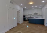 This 780-square-foot single-story residence in Washington, UT features 2 bedrooms and 3 bathrooms, designed with a clean, modern aesthetic. The open-concept kitchen and living area serves as the heart of the home, showcasing a striking two-tone kitchen with dark green lower cabinets, white upper cabinets, a white quartz island, stainless steel appliances including a gas range and dishwasher, and recessed lighting throughout. Light wood-style luxury vinyl plank flooring flows through the main living areas, entry corridor, and bathrooms, while neutral-toned carpet adds warmth to both bedrooms. The primary bedroom measures 130 square feet and includes a walk-in closet and an en-suite bathroom with a dark vanity and separate shower featuring a built-in niche. The second bedroom benefits from a large window that fills the space with natural light. All three bathrooms maintain a consistent modern design with clean white tiled showers, dark cabinetry, and white countertops. The living area includes a glass exterior door and large window providing additional natural light and outdoor access. The unit's crisp white walls, clean lines, and cohesive finishes create a bright, contemporary atmosphere throughout.