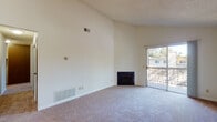 Located at 255 Coggins Dr in Pleasant Hill, California, this single-floor residence offers a well-organized layout with a variety of functional living spaces. The open living area immediately stands out with its soaring vaulted ceilings and clean white walls, creating a bright and airy atmosphere. A wood-burning fireplace serves as a focal point, while a sliding glass door opens directly onto a private balcony, inviting natural light and outdoor views into the space. The entryway connects seamlessly to the living area via hardwood-style flooring, with a pendant light fixture above adding a simple, clean detail. The galley-style kitchen features warm wood cabinetry, light butcher-block-style countertops, hardwood-style flooring, and white appliances including an electric range, refrigerator, and dishwasher, offering ample storage and workspace. The bedrooms are generously proportioned, each featuring plush carpeting, textured ceilings, and windows that bring in natural light. The bathroom is efficiently designed with a combined tub and shower, a wood-vanity with countertop, and hardwood-style flooring. Throughout the residence, a neutral color palette and practical finishes create a cohesive, move-in-ready environment.