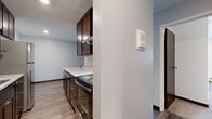 This 1-bedroom, 1-bathroom unit delivers a practical and comfortable layout on a single floor. The living area features light wood-tone flooring, a textured ceiling, and a large window fitted with vertical blinds that invites natural light and outdoor views. A wall-mounted HVAC unit and baseboard heating ensure year-round comfort.

The galley-style kitchen is thoughtfully designed with rich dark-brown cabinetry, light granite-look countertops, stainless steel appliances including a full-size refrigerator and electric range, and a range hood. Light hardwood-style flooring runs throughout the kitchen, which connects directly to the hallway leading to the rest of the unit.

The bedroom is generously sized, featuring plush wall-to-wall carpeting, a ceiling fan with integrated lighting, and a large window with vertical blinds for natural light control. Two louvered bi-fold closet doors provide ample storage on either side of the room.

The bathroom includes a tub-shower combination with clean, large-format white tile surrounds, offering a crisp and functional space. A connecting hallway ties all rooms together efficiently. Throughout the unit, neutral tones, dark wood accents, and updated fixtures create a cohesive and move-in-ready environment.