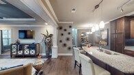 Located at 3400 S Bowman Rd in Little Rock, Arkansas, this single-floor residence showcases a thoughtfully designed open-concept layout with upscale finishes and cohesive contemporary styling throughout. The living area serves as the centerpiece of the home, featuring a distinctive tray ceiling with crown molding, elegant white decorative columns, rich hardwood flooring, and large windows that invite natural light. The space flows seamlessly into a well-appointed kitchen equipped with rich dark wood cabinetry, granite countertops, a mosaic tile backsplash, stainless steel appliances, and pendant lighting above the breakfast bar. The primary bedroom offers a tranquil retreat with plush carpeting, multiple windows, crown molding, and a ceiling fan. The en-suite primary bathroom is generously sized, boasting dual vanities with granite countertops, a deep soaking tub with granite surround, a separate glass-enclosed walk-in shower with tile accents, and recessed lighting. A second bedroom is equally comfortable, also featuring carpet and ample natural light. The secondary bathroom mirrors the home's refined aesthetic with granite countertops and dark wood cabinetry. An in-unit laundry area with a full-size washer and dryer adds everyday convenience. Overall, the residence presents a polished, upscale ambiance throughout.