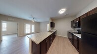 Located at 4712 Flat Shoals Rd in Union City, Georgia, this single-floor residence offers a well-designed, open-concept layout with consistent, modern finishes throughout. The kitchen serves as a central hub of the home, featuring rich dark espresso cabinetry, light granite-style countertops, black appliances including a refrigerator, range, and built-in microwave, and a peninsula that opens seamlessly into the living area. The living space is bright and inviting, with light wood-style flooring, neutral-toned walls, and a ceiling fan overhead. French doors provide access to a private outdoor area, allowing natural light to flow in. The bedrooms are generously sized, each equipped with a ceiling fan and large windows with blinds that offer views of the surroundings. Closet storage is well accommodated, with built-in shelving and hanging rods visible in the bedroom closets. The bathrooms are cleanly finished, featuring tile flooring, a tub/shower combination with brushed gold fixtures, and a dark-cabineted vanity with a large mirror. Additional storage shelving is also present near the bathroom area. The overall ambiance is clean, neutral, and move-in ready, making this a functional and comfortable single-floor home.