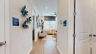 Located at 5020 Cedar Leaf Circle in Palmetto, FL, this single-story home offers a thoughtfully designed layout with two bedrooms, two bathrooms, and two closets. Light-toned hardwood flooring flows throughout, complementing the home's clean, coastal aesthetic.

The open-concept living and kitchen area forms the heart of the home. The living room is bright and airy, featuring recessed lighting, a ceiling fan, and large windows that invite abundant natural light. The kitchen is outfitted with white shaker cabinetry, stainless steel appliances, a large pantry, and a breakfast bar with pendant lighting — ideal for casual dining and entertaining.

The primary bedroom is a comfortable retreat with a ceiling fan and direct access to a private en-suite bathroom. The en-suite features a dual-sink vanity with quartz countertops, white cabinetry, a glass-enclosed shower, and leads directly into a spacious walk-in closet with wire shelving throughout. The second bedroom is well-sized, offering natural light through large windows and easy access to the second full bathroom. Both bedrooms maintain the home's consistent warm, coastal palette. A dedicated entrance and additional closet storage round out this efficiently designed, move-in ready home.