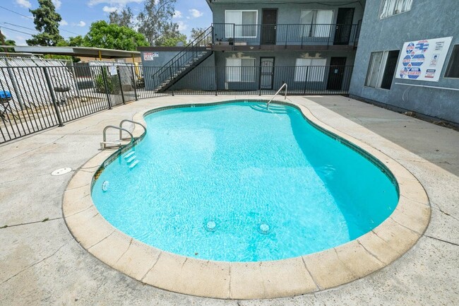 Villa Park a swimming pool with a blue water and a gray building in the background exterior pool area - Villa Park