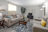 Located on Wrightsboro Road in Augusta, Georgia, this 2-bedroom, 2-bathroom single-story home offers a well-organized layout designed for comfortable everyday living. The living room serves as the heart of the home, featuring wood-look flooring, neutral-toned walls, and a textured ceiling. The space is generously sized to accommodate ample seating, and natural light filters in through windows dressed with cheerful curtains, creating a warm and inviting atmosphere.

The kitchen is outfitted with white cabinetry, speckled countertops, a double-basin sink beneath a bright window, and appliances including a range and dishwasher. It flows directly into the dining area, which features a sliding glass door that opens to a covered outdoor patio — ideal for extending living space to the exterior.

The primary bedroom offers a carpeted floor and a comfortable, cozy feel with closet access, while the second bedroom also features carpet and a window that brings in natural light. Both bathrooms are fitted with vanities featuring speckled countertops, white cabinetry, and mirrors with overhead lighting.

A central hallway connects the main living areas to the bedrooms, lined with louvered closet doors and wood-look flooring that carries throughout the common areas, contributing to a cohesive and functional design.
