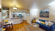 This well-appointed single-floor residence in Dacono, Colorado, offers a thoughtfully designed open-concept layout that seamlessly connects the living, dining, and kitchen areas. Warm hardwood flooring flows throughout the main living spaces, adding a sense of continuity and warmth. The living room is a standout, anchored by a tile-surround fireplace and a large window with sliding glass door access to a private balcony, flooding the space with natural light and outdoor views. A dedicated dining nook with built-in shelving sits adjacent, creating an inviting space for everyday meals. The kitchen is well-equipped with stainless steel appliances, including a refrigerator, range, and over-the-range microwave, complemented by white cabinetry, granite-style countertops, and a breakfast bar that opens to the living and dining areas. The bedroom is a serene retreat featuring soft carpeting, a soothing color palette, a large window for natural light, and a walk-in closet offering generous storage. The bathroom is finished with white cabinetry, granite-style countertops, a large vanity mirror, and a shower/tub combination. Throughout, the space maintains a cohesive, comfortable aesthetic ideal for everyday living.