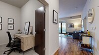 Located at 360 N First St in Minneapolis's vibrant North Loop neighborhood, this thoughtfully designed one-bedroom, one-bathroom residence offers a smart, functional layout across a single floor. Rich hardwood flooring flows throughout the main living areas, anchoring the open-concept kitchen and living room. The kitchen is equipped with stainless steel appliances, dark espresso cabinetry, a tile backsplash, granite countertops, and a peninsula with bar seating illuminated by pendant lighting. The living area connects seamlessly to a private balcony through large sliding glass doors, bringing in generous natural light and urban views. A dedicated office space provides a quiet retreat with room for a desk, shelving, and seating. The carpeted bedroom features a large window with city views and a spacious closet. The bathroom is finished with classic white subway tile surrounding the soaking tub and shower, a floating dark-wood vanity, and neutral tile flooring. A separate closet and entryway with additional storage complete the layout. The overall aesthetic is modern and clean, with neutral tones, contemporary fixtures, and thoughtful details throughout.