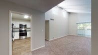 This single-floor residence offers a thoughtfully designed layout with a mix of modern finishes and comfortable living spaces. The living area is a standout, boasting soaring vaulted ceilings with exposed beams and elevated clerestory windows that flood the space with natural light. Soft, neutral-toned carpet flows throughout the living and bedroom areas, complementing the warm hardwood-style flooring found in the kitchen and bathroom.

The kitchen is well-equipped, featuring crisp white shaker cabinetry with matte black hardware, granite countertops, a stainless steel undermount sink, and a full suite of stainless steel appliances including a range, built-in microwave, and dishwasher. The space is functional and stylish, ideal for everyday cooking.

The bathroom showcases a clean, contemporary aesthetic with large-format white wall tiles surrounding a soaking tub and shower combination, accented by matte black fixtures. The vanity area features a granite countertop, an undermount sink, white cabinetry, and a backlit LED mirror that adds a refined touch.

The bedrooms are generously proportioned, with plush carpet, neutral walls, and windows providing natural light. The entry area benefits from the dramatic vaulted ceiling and opens seamlessly into the main living space, creating an airy, welcoming atmosphere throughout.