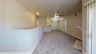 Located in Oro Valley, Arizona, this single-story space offers a clean, neutral aesthetic throughout. The open-concept living area is generously proportioned, featuring plush wall-to-wall carpeting, crisp white baseboards, and a ceiling fan with integrated lighting. A half-wall partition defines the space while maintaining an airy, connected feel. Natural light enters through blinds-fitted windows, with one room showcasing a charming circular accent window. A private exterior door provides convenient direct access from one of the rooms.

The galley-style kitchen is well-appointed with white shaker cabinetry, light granite countertops, wood-look plank flooring, and stainless steel appliances including a range and microwave. Track lighting illuminates the workspace effectively, and a stainless steel sink with a view into the adjoining area rounds out the functional layout.

Two bathrooms mirror each other in design, each featuring white vanity cabinetry topped with granite counters, a framed mirror with a multi-bulb vanity light fixture, a tub-shower combination, and wood-look plank flooring. The overall palette throughout the space is light and neutral, contributing to a bright, move-in-ready ambiance suited to the sunny Sonoran Desert setting.