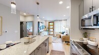 Located at 1331 Chester Ave in Raleigh's desirable 27608 zip code, this single-floor residence showcases a contemporary design with a warm, cohesive aesthetic throughout. Light hardwood flooring flows seamlessly across the open-concept layout, complemented by recessed lighting and a neutral color palette that creates an airy, inviting atmosphere.

The kitchen is a standout feature, offering gray shaker-style cabinetry, stainless steel appliances including a French door refrigerator and range, a white subway tile backsplash, a matte black fixture sink, and a generous island with quartz countertops and pendant lighting — ideal for both cooking and casual dining.

The living area is bright and welcoming, anchored by a warm-toned wood front door with glass panels that invite natural light, alongside a large window with sheer curtains. A dedicated mudroom nook with a built-in bench and wall hooks provides practical entryway storage.

The bedroom is a serene retreat, featuring a ceiling fan, natural light from a well-dressed window, and ample space. A walk-in closet with built-in shelving and hanging storage adjoins the room, while a full bathroom with gray vanity cabinetry, a large mirror, and tile flooring completes the private quarters. A stacked laundry area adds everyday convenience.