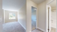 This single-floor residence offers a thoughtfully designed layout that balances comfort and functionality throughout. The spacious living room serves as the heart of the home, anchored by a classic fireplace framed by a raised mantel and flanked by two large windows that fill the room with abundant natural light and views of lush greenery outside. Plush carpeting flows throughout the living areas and bedrooms, adding warmth underfoot.

The kitchen is well-equipped with stainless steel appliances, including a refrigerator and electric range, complemented by light wood cabinetry, a tiled backsplash, and a peninsula with white countertops and an undermount sink — ideal for both cooking and casual dining. Light wood-style flooring grounds the kitchen area with a clean, contemporary feel.

The bedrooms are generously proportioned, each featuring carpeted floors, neutral walls, and windows that invite natural light. One bedroom includes access to a dedicated closet space with track lighting.

Two bathrooms serve the home. The first features a tub-shower combo with grab bar, a wood-toned vanity, white countertop, and a large mirror. The second offers a sliding-door shower stall, wood-look tile flooring, and a white countertop vanity. Together, they provide practical, well-finished spaces that complete this comfortable single-floor home.