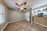 This well-appointed 1-bedroom, 2-bathroom unit is thoughtfully designed to maximize every square foot across a single floor. The open-concept living, dining, and kitchen area forms the heart of the home, finished with warm wood-look flooring and neutral taupe walls throughout. A ceiling fan with integrated lighting anchors the living space, complemented by a textured ceiling that adds character. The kitchen features white cabinetry, granite-style countertops, a mosaic tile backsplash, stainless steel appliances including a built-in microwave, and a breakfast bar that connects seamlessly to the living and dining areas. A stacked washer and dryer unit is conveniently integrated into the living space, offering in-unit laundry without sacrificing functionality. The bedroom is a comfortable retreat with its own wood-look flooring, a window with blinds that invites natural light, and access to a closet for ample storage. The two bathrooms provide added convenience, with one featuring a full tub-shower combination with clean white surround. Two dedicated closets ensure practical storage throughout. The overall ambiance is clean, modern, and move-in ready, making this a highly functional and efficiently designed living space.