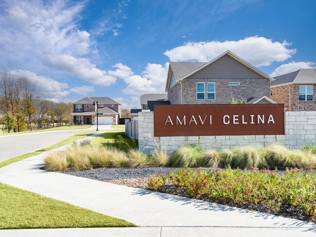 A distinctive community entry framed by landscaped greens and sidewalks, offering a warm first impression of this single-family neighborhood in Celina. - Amavi Celina