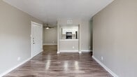 Located at 1301 Sycamore School Rd in Fort Worth, Texas, this 2-bedroom, 1-bathroom single-story home offers a clean, functional layout with modern finishes throughout. The open-concept living area features warm wood-look plank flooring, neutral wall tones, and a standout marble-surround fireplace as the focal point. A sliding glass door floods the room with natural light while providing access to an outdoor area. The kitchen is designed as a galley-style corridor, outfitted with white shaker cabinetry, granite-look countertops, and black appliances including a range and refrigerator. A pass-through opening connects the kitchen to the main living space, enhancing the open feel. Both bedrooms are comfortably sized, finished with soft carpet, ceiling fans with lighting, and windows fitted with blinds for natural light and privacy. Each bedroom includes closet storage. The primary bedroom offers a generous footprint with its own closet access. The bathroom is clean and functional, featuring a full tub-shower combination with tile surround and brushed nickel fixtures. Two dedicated closets provide additional storage throughout the home, making this a practical and well-appointed residence.