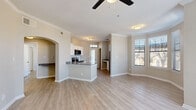 This thoughtfully designed 2-bedroom, 2-bathroom single-floor residence offers a functional and comfortable layout across a well-proportioned floor plan. Light wood-style flooring runs consistently throughout, creating a cohesive and clean aesthetic from room to room.

The living room serves as the heart of the home, featuring a classic white-mantled fireplace, crown molding, a ceiling fan, and multiple windows fitted with horizontal blinds that invite natural light. An elegant arched passageway connects the living area to the rest of the home.

The kitchen is equipped with stainless steel appliances, white cabinetry, subway tile backsplash, and dark countertops. A peninsula provides additional prep and dining space, while a transom-topped entry door and a dedicated window bring in abundant natural light.

The primary bedroom offers a comfortable footprint with a bay window configuration, providing generous views and light. It is complemented by a walk-in closet with built-in wire shelving. Both bathrooms feature white cabinetry, dark countertops, brushed nickel fixtures, and framed mirrors, with one bathroom including a full tub-shower combination.

The second bedroom is a well-sized, neutral room with ample wall space. Additional spaces include two hallways, two closets, and a utility room, rounding out a practical and livable floor plan.