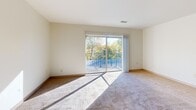 Located at 150 North Ave in Tallmadge, Ohio, this 2-bedroom, 1-bathroom single-floor residence offers a practical and comfortable layout. The combined kitchen and living area serves as the heart of the home, where warm wood-toned cabinetry, subway tile backsplash, dark countertops, and stainless steel appliances — including a gas range and full-size refrigerator — create a functional yet stylish kitchen. A decorative chandelier adds character to the space, while light hardwood-style flooring flows throughout. The living area transitions seamlessly from the kitchen and features sliding glass doors that open to a private balcony overlooking lush, tree-lined surroundings, filling the room with natural light. Both bedrooms are carpeted and well-proportioned, each featuring windows that invite natural light and ample closet space. The spacious primary bedroom includes a dedicated closet and easy access to the hallway. The full bathroom is finished with white tile surrounding a tub-shower combination, complemented by over-toilet storage cabinetry. Three closets throughout the unit provide generous storage. Neutral tones, clean lines, and a well-connected layout define the overall ambiance of this residence.