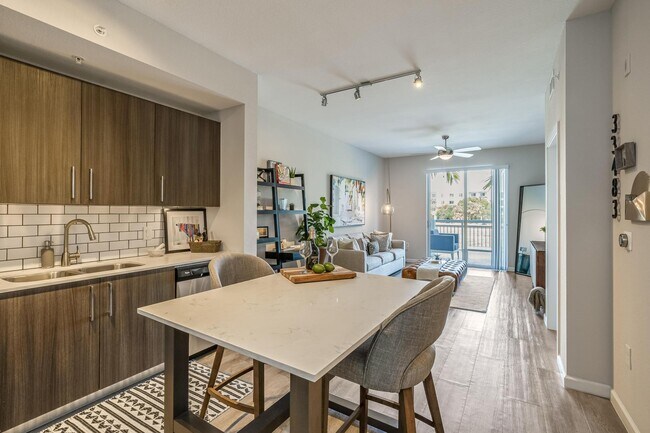 Isla con asientos y cocina completa frente a sofá y puertas corredizas - South of Atlantic Luxury Apartments