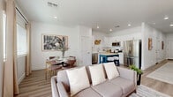 Located in Phoenix, AZ, this two-story, 2-bedroom, 3-bathroom home offers a clean, contemporary design with light-toned luxury vinyl plank flooring and crisp white walls throughout. The main floor opens into a bright, open-concept living, dining, and kitchen area. The kitchen is well-appointed with white shaker cabinetry, subway tile backsplash, stainless steel appliances, and a butcher-block island with seating — ideal for both cooking and casual entertaining. The adjacent dining area features a large window that brings in natural light, while the living room is anchored by a ceiling fan and recessed lighting. A full bathroom and staircase with wood-toned treads and a white rail complete the ground floor. Upstairs, the generously sized primary bedroom features vaulted ceilings, a ceiling fan, large windows, plush carpeting, and dedicated closet space. Additional bedrooms and bathrooms on this floor provide ample accommodation. The bathrooms are finished with large-format tile surrounds, glass-enclosed walk-in showers, and white vanities. A dedicated laundry room with a full-size washer and dryer adds everyday convenience. The home's cohesive neutral palette and modern finishes create a polished, move-in-ready atmosphere throughout.