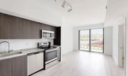 Located at 22555 SW 107th Ave in Miami, FL, this modern single-floor residence offers two bedrooms, two bathrooms, a dedicated laundry area, a utility room, and two closets. The open-concept layout connects the kitchen and living area seamlessly, creating an efficient and functional flow throughout the space. Light wood-style flooring runs throughout, complementing the clean white walls and contemporary aesthetic.

The kitchen is well-appointed with dark espresso-toned cabinetry, granite-style countertops, a white tile backsplash, and a full suite of stainless steel appliances including a French door refrigerator, electric range, built-in microwave, and dishwasher. Track lighting overhead adds a modern touch. A sliding glass door in the living area fills the space with natural light and provides views of the outdoors.

Both bedrooms are bright and airy, each featuring windows with horizontal blinds that allow for adjustable natural light and light wood-style flooring. The two bathrooms are finished consistently with dark vanity cabinetry, granite-style countertops, large mirrors, and shower-tub combos, maintaining the home's cohesive modern design throughout. The overall ambiance is clean, contemporary, and move-in ready.