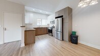 This two-story, 2-bedroom, 2-bathroom residence in Norwalk, California offers a thoughtfully designed layout spread across two floors. The main level features a bright, open living room with light wood-style flooring, high ceilings, and a sliding glass door fitted with vertical blinds that opens to one of two private balconies, providing pleasant outdoor views. The adjacent dining area connects seamlessly to a well-appointed kitchen, which boasts two-tone cabinetry — white uppers paired with warm wood-toned lowers — a classic subway tile backsplash, stainless steel appliances including a gas range, microwave, and French door refrigerator, and recessed lighting. An in-unit laundry area adds everyday convenience. The upper level houses both bedrooms, each carpeted for comfort. The primary bedroom features vaulted ceilings, mirrored closet doors, and a window that fills the space with natural light. The second bedroom also includes carpeting, a vaulted ceiling, and access to the second balcony via a sliding glass door. Both bathrooms are clean and functional, featuring wood-look flooring, a tub-shower combination, and a vanity with warm wood cabinetry and a broad mirror. Multiple closets throughout offer ample storage.