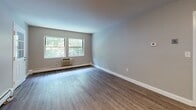 Located at 110 Olde Derby Rd in Norwood, Massachusetts, this single-floor unit offers a well-organized layout designed for comfortable everyday living. The open entryway welcomes you with warm hardwood-style flooring that extends through the main living and dining areas, creating a cohesive and inviting atmosphere. Natural light filters in through multiple windows, offering pleasant views of the surrounding greenery.

The kitchen is a functional highlight of the space, featuring rich honey-toned wood cabinetry, ample counter space, a stainless steel sink, and full-size appliances including a dishwasher, range, and refrigerator — all finished with the same durable hardwood-style flooring.

The bedrooms are carpeted for added comfort and are finished in soft, neutral tones. One bedroom includes direct access to a dedicated walk-in closet, providing generous storage. Each bedroom is equipped with baseboard heating and a wall-unit air conditioner, ensuring year-round climate control. Windows in the bedrooms frame views of the lush outdoor landscape.

The bathroom is cleanly appointed with white tile flooring, a tub-shower combination, a single vanity with under-sink storage, and a mirrored medicine cabinet. Chrome fixtures and overhead lighting complete the bright, tidy design. Overall, the unit presents a practical and comfortable living environment in a well-established Norwood location.