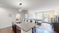 Located in Swiftwater, Pennsylvania, this well-appointed single-floor residence offers a functional and stylish layout across one bedroom, two bathrooms, a dedicated office, and an open-concept kitchen and living area. Rich, dark hardwood-style flooring runs throughout, providing a cohesive and polished look in every room.

The combined kitchen and living room serves as the heart of the home. The kitchen features dark espresso cabinetry, granite countertops, a classic white subway tile backsplash, and stainless steel appliances. The living area is bright and inviting, with large windows that frame views of the surrounding greenery and a glass-panel exterior door that fills the space with natural light.

The spacious primary bedroom maintains the same warm aesthetic, with clean white walls and ample room for a full furniture arrangement. The dedicated office provides a bright, quiet workspace with its own window and natural light.

Both bathrooms are finished to a high standard. One features a wood-toned vanity with a backlit mirror, while the other showcases a floor-to-ceiling marble-style walk-in shower with a frameless sliding glass door. A dedicated laundry room with a water heater adds everyday convenience. The overall ambiance is clean, modern, and comfortable.