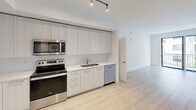 Located on the fifth floor at 103 W Camino Real in the heart of Boca Raton, FL, this contemporary apartment offers 2 bedrooms and 3 bathrooms across a well-designed single-level layout. Light wood-style flooring flows throughout, creating a bright and cohesive aesthetic complemented by crisp white walls and clean-lined architecture.

The modern kitchen is outfitted with stainless steel appliances — including a French door refrigerator, electric range, microwave, and dishwasher — alongside sleek two-tone cabinetry, light countertops, and track lighting overhead. It opens seamlessly into the living area, enhancing the sense of openness.

Both bedrooms are generously proportioned, with large windows fitted with blinds that invite natural light and offer views of the surrounding neighborhood. The spacious primary bedroom includes access to a dedicated closet with built-in wire shelving for organized storage.

The three bathrooms are finished to a high standard, featuring large-format tile work. One bathroom includes a full soaking tub with a tiled surround, while another showcases a walk-in glass-enclosed shower. All bathrooms feature clean white vanities and modern fixtures.

A hallway connects the private areas of the home, and two closets provide ample storage throughout. The overall ambiance is modern, airy, and move-in ready.