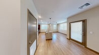Located at 7521 N Tule Springs Rd in Las Vegas, NV, this single-story, 3-bedroom, 2-bathroom residence offers a thoughtfully designed open-concept layout. The heart of the home is the kitchen, which features rich wood-tone cabinetry, granite countertops, stainless steel appliances including a gas range, built-in microwave, and French door refrigerator, and a central island with a undermount sink illuminated by stylish globe pendant lights. The kitchen flows seamlessly into a bright, spacious living area finished with light wood-style flooring, recessed lighting, and a ceiling fan, with multiple windows allowing abundant natural light. Each of the three bedrooms is carpeted and equipped with a ceiling fan, providing comfort and warmth. The primary bedroom is generously sized and includes its own closet. The two bathrooms mirror the home's modern aesthetic, featuring wood-tone vanity cabinetry, granite countertops, backlit mirrors, and a shower-tub combination. A dedicated laundry room houses a full-size side-by-side washer and dryer with overhead shelving for additional storage. Three closets throughout the unit provide ample storage. The consistent use of quality finishes and neutral tones gives this residence a clean, contemporary character throughout.