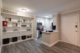 Located at 15215 Blue Ash Dr in Houston, Texas, this single-floor residence offers a clean, contemporary design with consistent wood-look flooring and a neutral color palette that creates a cohesive, welcoming atmosphere throughout.

The kitchen is a functional highlight of the space, designed in a galley layout with crisp white cabinetry, quartz-style countertops, and a full suite of stainless steel appliances including an electric range, built-in microwave, dishwasher, and refrigerator. A kitchen island with a sink adds convenience and workspace, while a pass-through opening connects the kitchen to a built-in shelving unit — an ideal feature for display or additional storage.

The living and bedroom areas are finished with the same wood-look flooring, providing a seamless flow between spaces. Each room is equipped with a ceiling fan, and large windows with horizontal blinds allow for ample natural light while maintaining privacy. The rooms are generously proportioned, offering a comfortable and versatile layout.

The bathroom is well-appointed with white cabinetry, a quartz-style vanity countertop, a full tub-shower combination with clean white tile surround, and matching wood-look flooring that ties the space together. The overall ambiance of this residence is bright, modern, and move-in ready.
