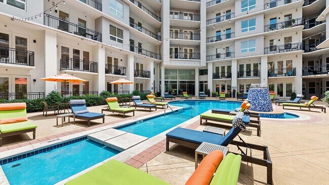 Área de piscina estilo resort Griffis Uptown con tumbonas. - Griffis Uptown