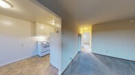 Located at 1201 Liberty St in El Cerrito, California, this single-floor unit offers a practical and well-organized layout. The kitchen is efficiently designed with white cabinetry providing ample storage, a coil electric range, a stainless steel sink, and a full-size refrigerator, all set on durable tile flooring. The space transitions into a carpeted hallway that connects the living areas and bedrooms.

The living room is bright and welcoming, featuring large windows that frame views of surrounding greenery and allow generous natural light to fill the space. The room opens to additional areas, enhancing the sense of flow throughout the unit. Two carpeted bedrooms offer comfortable, quiet retreats, each with windows that provide natural light and neighborhood views.

The bathroom is neatly appointed with a white vanity, under-sink cabinetry, a toilet, and a tub and shower combination enclosed by sliding glass doors. Tile flooring completes the clean, functional aesthetic of the space.

Throughout the unit, neutral wall tones and carpet in varying shades of blue, tan, and gray create a calm, cohesive atmosphere. The single-floor layout ensures easy accessibility, making this a straightforward and functional living space in a convenient El Cerrito location.