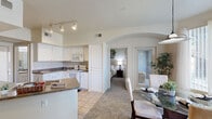Located at 5150 N 99th Ave in Phoenix, AZ, this single-story, one-bedroom, one-bathroom residence offers a thoughtfully designed layout that maximizes comfort and functionality. The open-concept living, dining, and kitchen area serves as the heart of the home, where a cozy fireplace anchors the carpeted living room alongside a ceiling fan and large window that fills the space with natural light. An arched architectural detail elegantly connects the living and dining areas, where a pendant light illuminates a bright dining space with floor-to-ceiling windows and direct access to the private patio. The kitchen features white cabinetry, dark countertops, tile flooring, a breakfast bar peninsula, track lighting, and white appliances, offering ample storage and workspace. The bedroom provides a serene retreat with plush carpeting, a ceiling fan, natural light from a window, and direct access to both the bathroom and a dedicated closet. The full bathroom is finished with tile flooring, a vanity, and a shower-tub combination. Additional conveniences include an in-unit laundry area and a private outdoor patio, rounding out this efficient and inviting Phoenix residence.