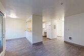 Located at 10110 19th Ave SE in Everett, Washington, this one-bedroom, one-bathroom unit offers a functional and well-organized single-floor layout. The open-concept living and kitchen area forms the heart of the home, where wood-look flooring runs throughout and neutral, light-toned walls create a clean, bright atmosphere. The kitchen features a pass-through breakfast bar, white cabinetry with ample storage including open shelving, a full-size refrigerator, an electric range, and an under-cabinet range hood — all oriented toward the living space to encourage an open, connected feel. The living room is generously proportioned with a wall-mounted heater and access to natural light. A hallway connects the main living area to the private quarters, where a sliding-door closet provides additional storage. The bedroom is carpeted for comfort, includes a double sliding-door closet, a baseboard heater, and a window that brings in natural light and outdoor views. The bathroom is designed with accessibility in mind, featuring grab bars, an open vanity with white cabinetry, a large mirror, wood-look tile flooring, and a full soaking tub with a shower. This unit offers a straightforward, practical layout suited for comfortable everyday living.