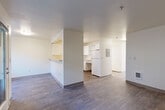 Located at 10110 19th Ave SE in Everett, Washington, this one-bedroom, one-bathroom unit offers a functional and well-organized single-floor layout. The open-concept living and kitchen area forms the heart of the home, where wood-look flooring runs throughout and neutral, light-toned walls create a clean, bright atmosphere. The kitchen features a pass-through breakfast bar, white cabinetry with ample storage including open shelving, a full-size refrigerator, an electric range, and an under-cabinet range hood — all oriented toward the living space to encourage an open, connected feel. The living room is generously proportioned with a wall-mounted heater and access to natural light. A hallway connects the main living area to the private quarters, where a sliding-door closet provides additional storage. The bedroom is carpeted for comfort, includes a double sliding-door closet, a baseboard heater, and a window that brings in natural light and outdoor views. The bathroom is designed with accessibility in mind, featuring grab bars, an open vanity with white cabinetry, a large mirror, wood-look tile flooring, and a full soaking tub with a shower. This unit offers a straightforward, practical layout suited for comfortable everyday living.