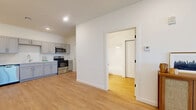Located at 1060 Crest Way in York, PA, this thoughtfully designed one-bedroom, one-bathroom unit offers a clean, modern aesthetic with light hardwood-style flooring and crisp white walls throughout the main living areas. The open-concept kitchen and living room create a functional, cohesive space. The kitchen is well-appointed with gray shaker-style cabinetry, white countertops, a stainless steel refrigerator, dishwasher, electric range, and over-the-range microwave — providing ample storage and a complete suite of appliances. The living area offers a comfortable, bright environment with recessed lighting and easy access to the front entry. The bedroom features plush carpet, a louvered closet door, and a natural light-admitting window. A standout detail is the stylish sliding barn door that connects the bedroom to the full bathroom, which includes a gray vanity with white countertop, a lighted mirror, and a tub-shower combination. A dedicated laundry room with a full-size Whirlpool washer and dryer adds everyday convenience. The unit's layout is efficient and well-organized, making excellent use of its compact footprint while maintaining a modern, move-in-ready feel.